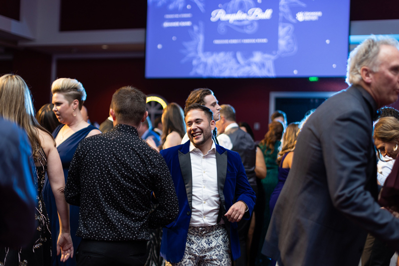 Dancers enjoy the ballroom floor and the presentation screen is visible in the background